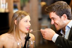 Mann füttert Frau beim romantischen Abendessen
