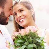 Frau freut sich über Blumen von ihrem Partner