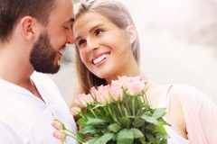 Frau freut sich über Blumen von ihrem Partner